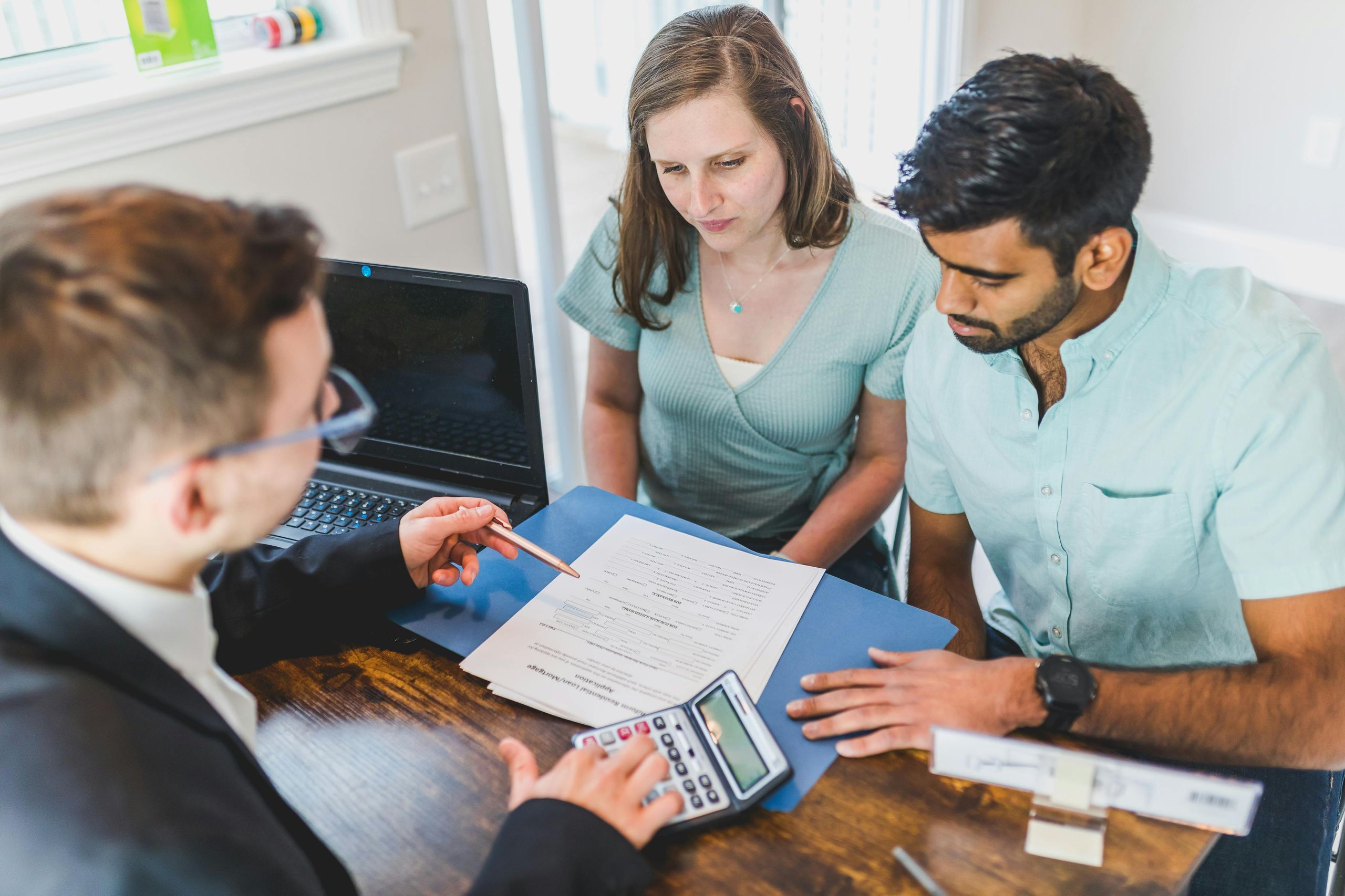 First-time buyers signing property purchase documents at solicitor's desk