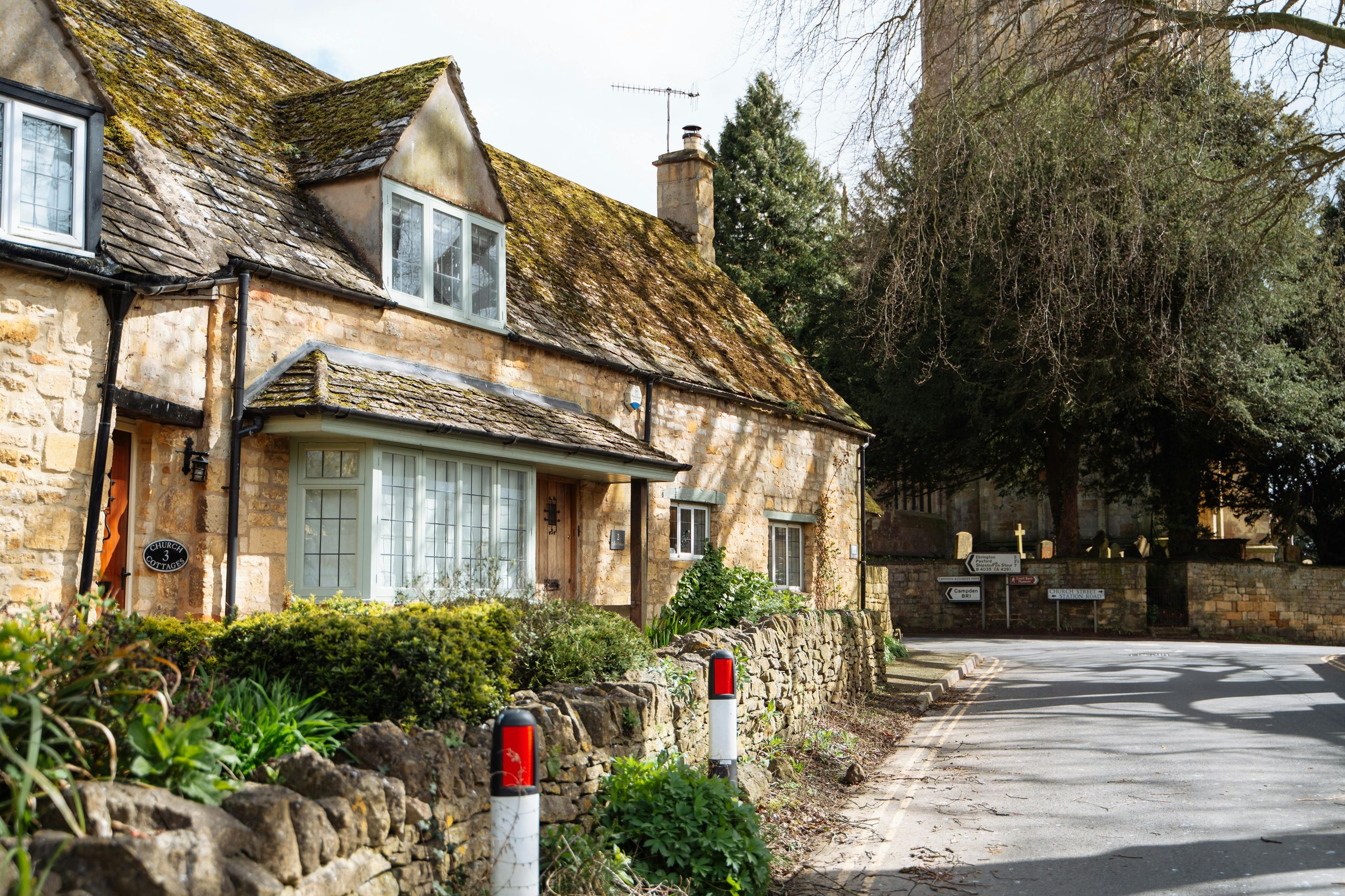 RICS surveyor documenting a historic listed stone cottage in the English countryside