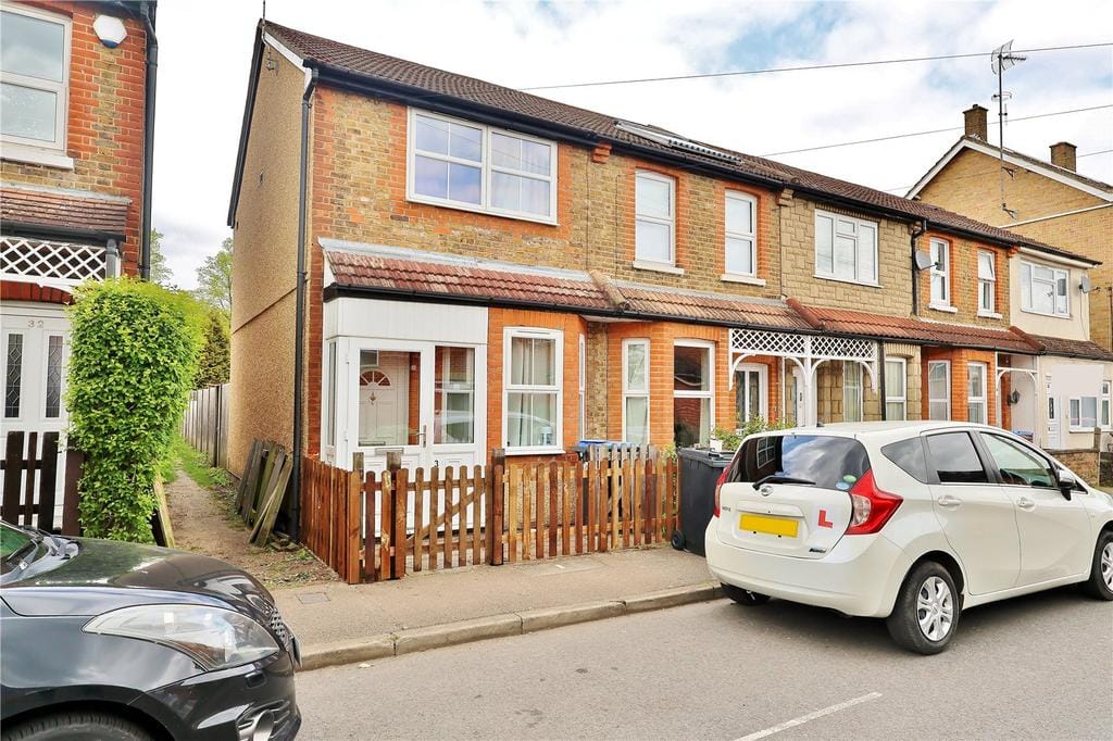 Surrey residential street with estate agent for sale boards on a sunny day